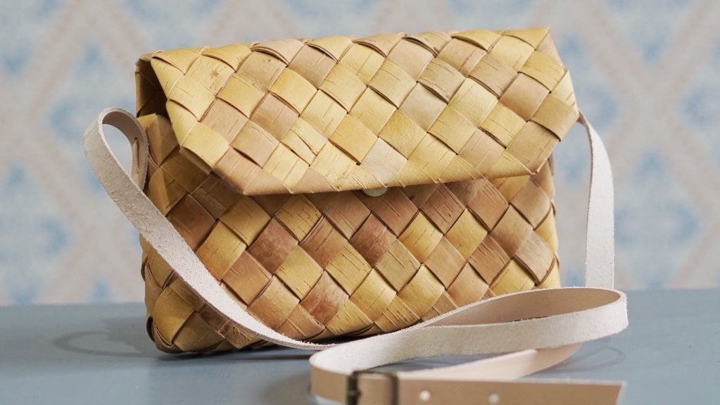 Handtasche aus Birkenrinde mit Lederriemen vor Schwedentapete im Mys Shop