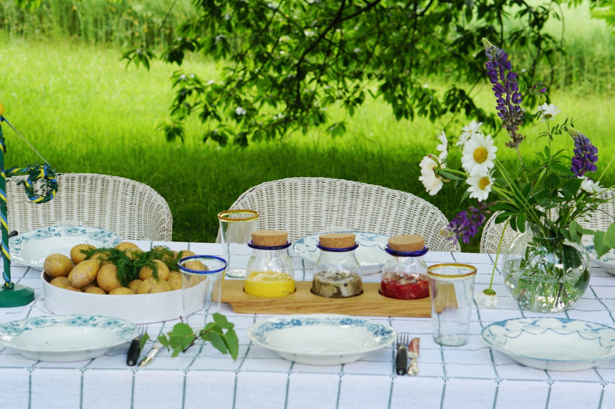 Tisch mit Fisch Kartoffeln Sommerblumen zu Mittsommer in Schweden