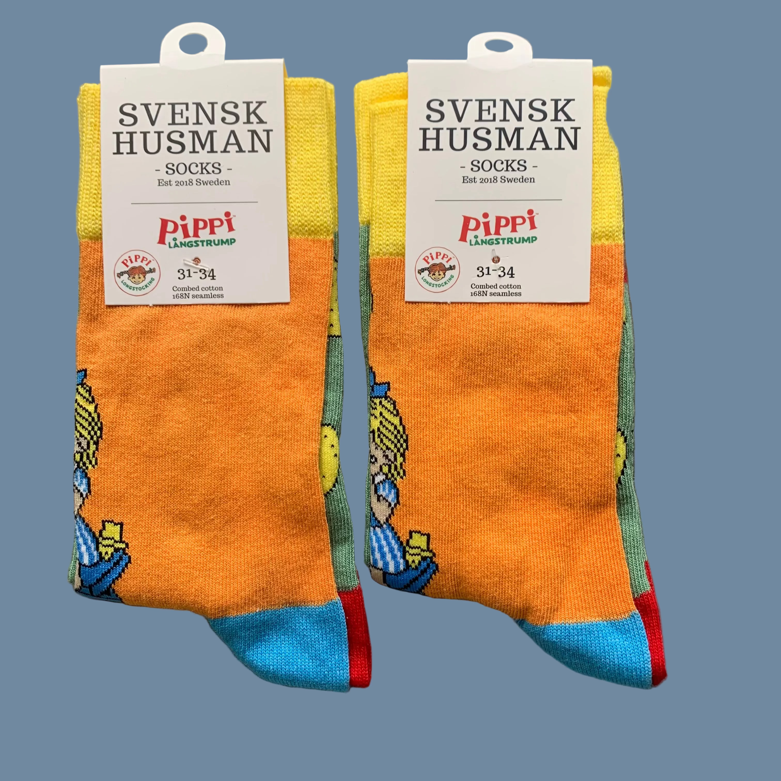 2 Paar Kinder Socken Pippi bäckt Plinsen vor mysblauem Hintergrund