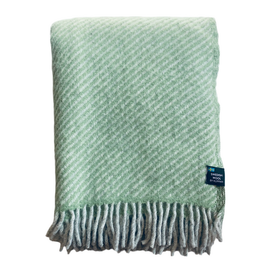 Wolldecke aus Lammwolle Carl grün mit dicken grauen Fransen zusammengefaltet vor neutralem Hintergrund