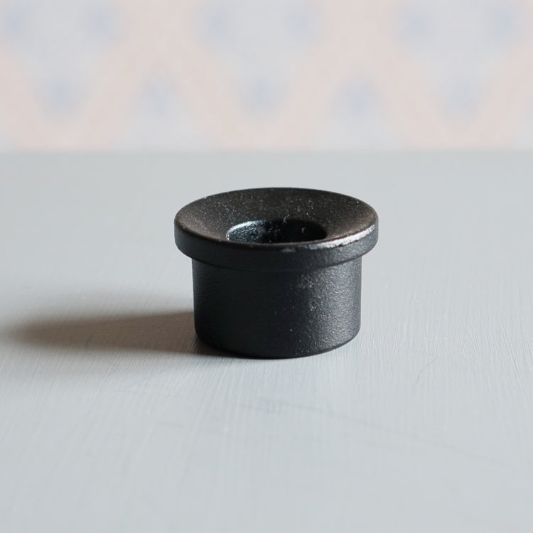 Kerzenhalter Adapter aus Metall in Farbe schwarz auf Tisch vor schwedischer Tapete