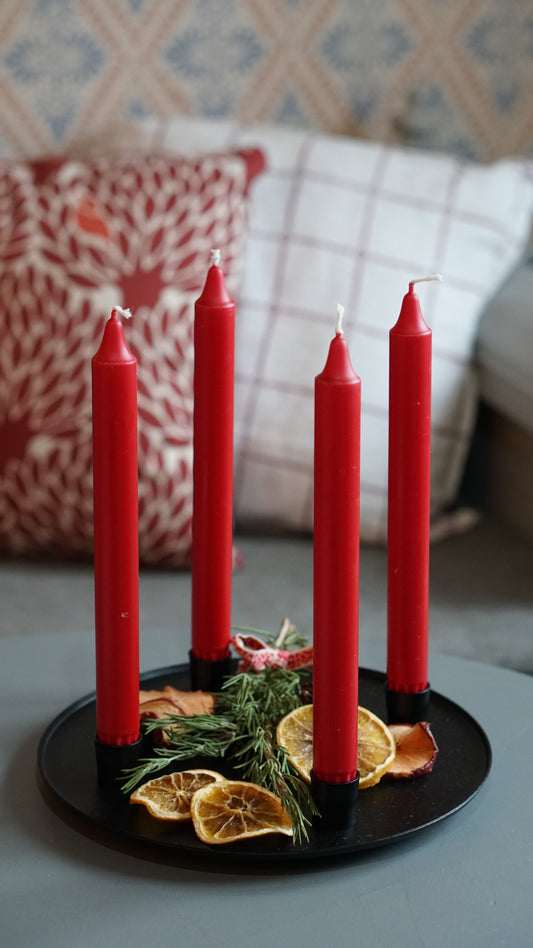 Adventskerzenhalter mit vier roteen Adventskerzenhalter mit vier roten Kerzen Kerzen und Deko auf Tisch vor schwedischem Küchensofa