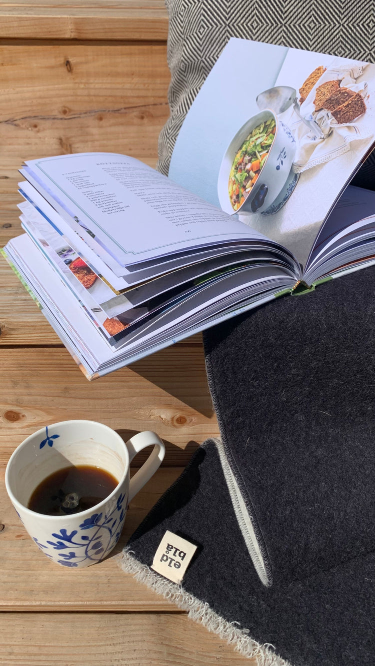 Astrid_Lindgren Kochbuch liegt aufgeschlagen auf Verandatreppe neben Kaffeetasse