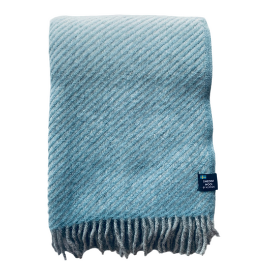 Wolldecke aus Lammwolle Carl mit dicken grauen Fransen zusammengefaltet vor neutralem Hintergrund