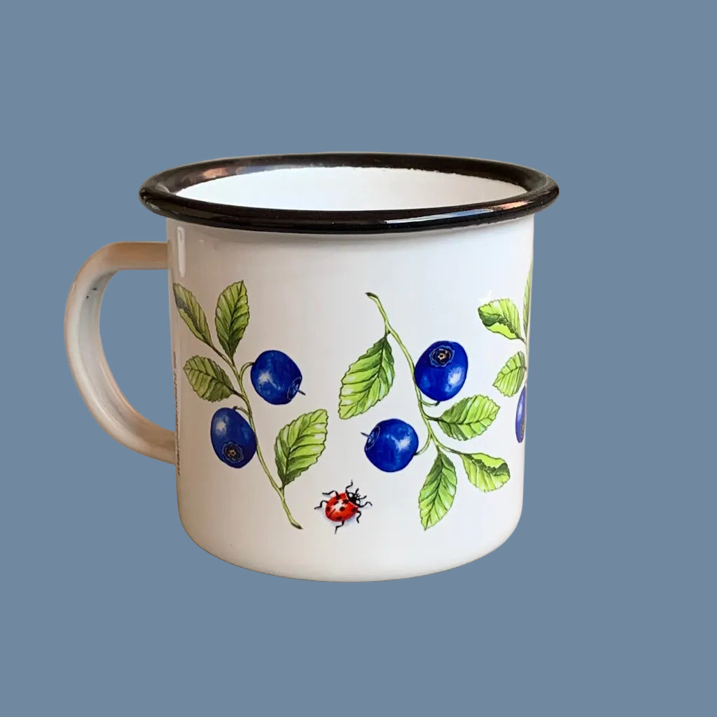 linke Seite der Emaille Tasse mit Blaubeeren vor mysblauem Hintergrund