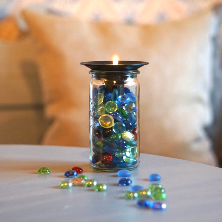 Glas gefüllt mit Glasnuggets, obenauf Kerzenhalter Burk mit brennendem Teelicht