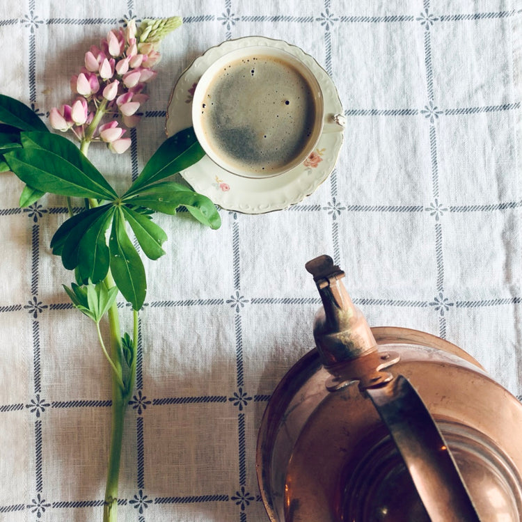 Flatlay Tischläufer weiß mit grau mit Kaffeetasse, Lupine und Kupferkessel
