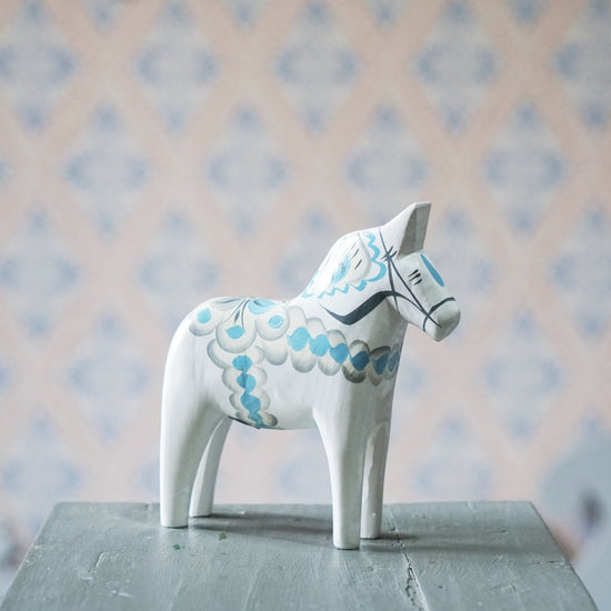 seitlich schräge Ansicht des Dalpferdes August in weiß mit hellblauer Bemalung
