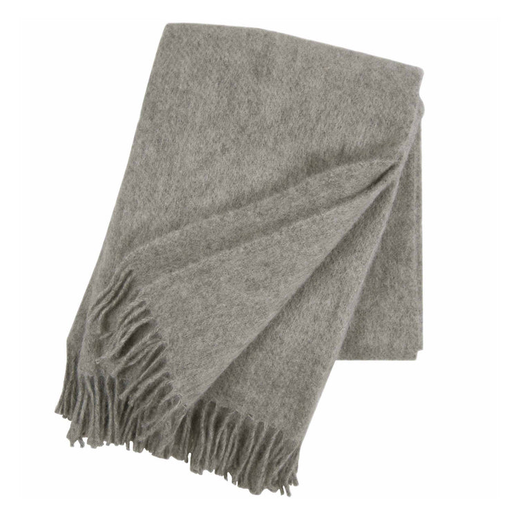 graue Gotlanddecke zusammengefaltet, man sieht schön die Graumelierung, das Grau ist nicht schreiend, eine Ecke ist nch außen geklappt, man sieht, dass Vorder- und Rüückseite der Decke die gleiche Farbe haben