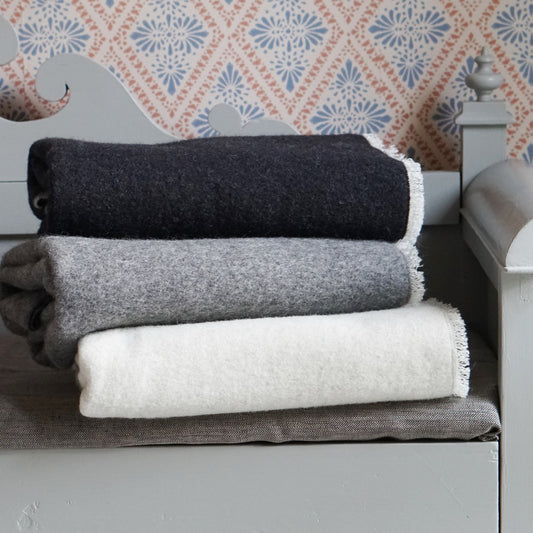 drei Wolldecken gefaltet übereinander auf Küchenbank liegend