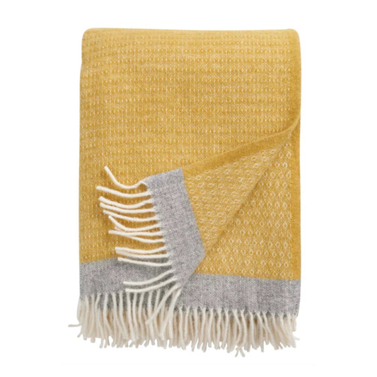 Wolldecke Harald in gelb zusammengefaltet, an der unteren Kante ein grauer Streifen und weiße Fransen