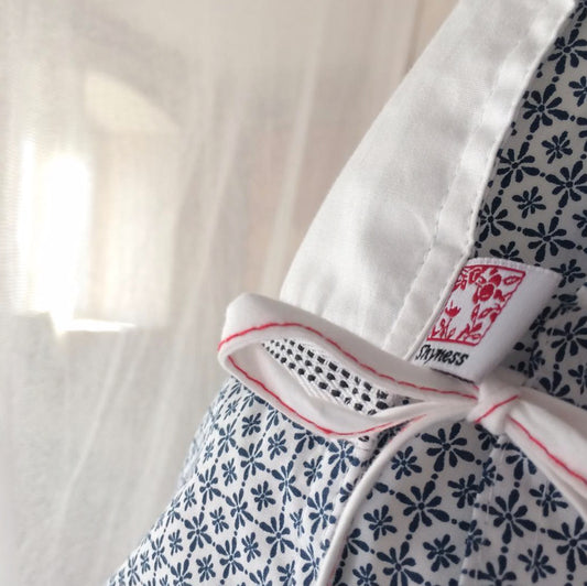 Verschlussband am Kopfkissen das auf Bett vor einer dünnen weißen Gardien steht