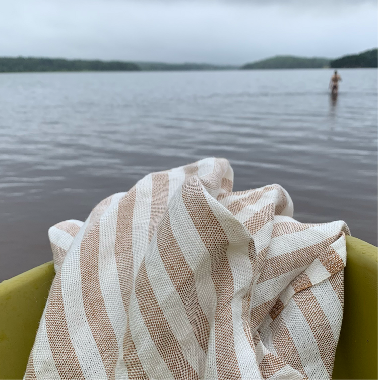 Badetuch Regnbåge aus Leinen in ziegelrot/sand auf Boot am See