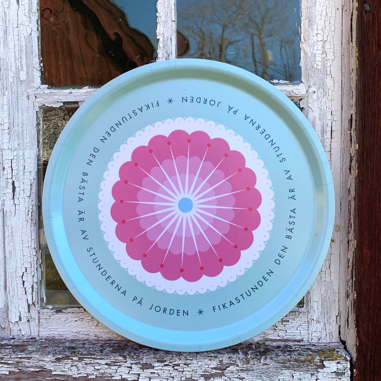 Rundes Tablett „Fikastund“ lehnt außen an der Fensterscheibe eines alten schwedischen Holzhauses