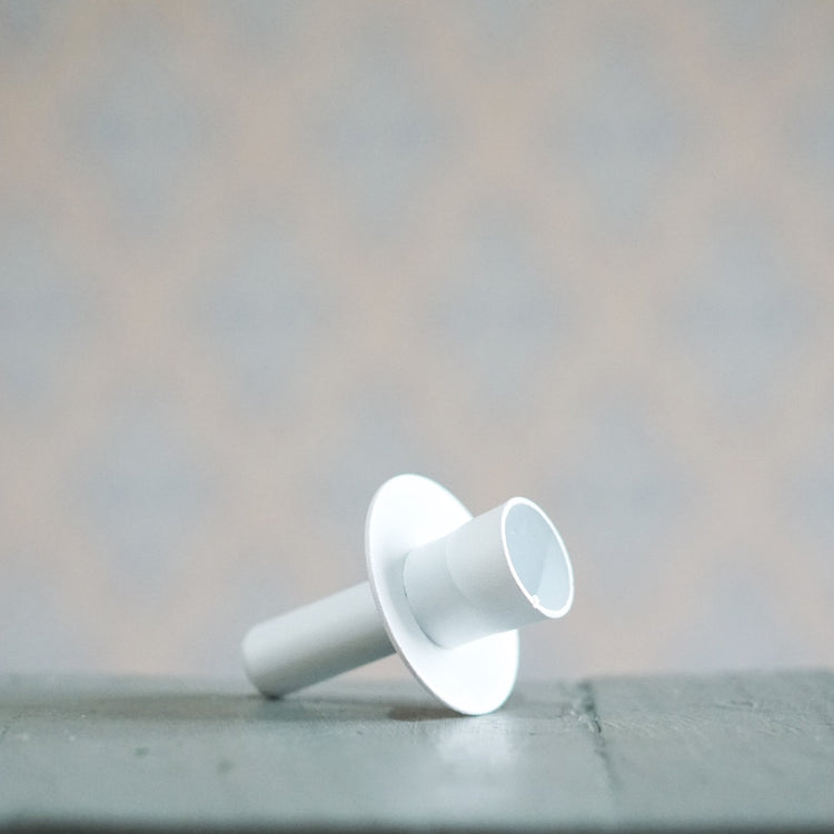 Kerzenhalter Flaska in weiß aus Metall von Våges liegend auf einem Tisch