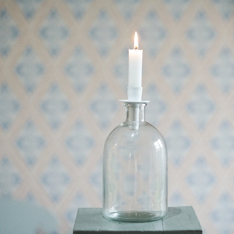 Kerzenhalter Flaska aus Metall in weiß mit brennender Kerze auf einer Flasche