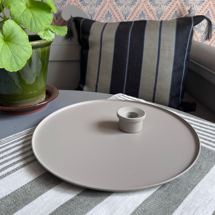 Kerzenteller und Kerzenhalter kalk in romantischem Setting auf Tisch mit Pelargonie