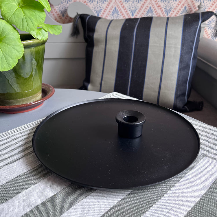 Kerzenteller und Kerzenhalter schwarz aus Metall in romantischem Setting auf schwedischem Tisch mit Pelargonie