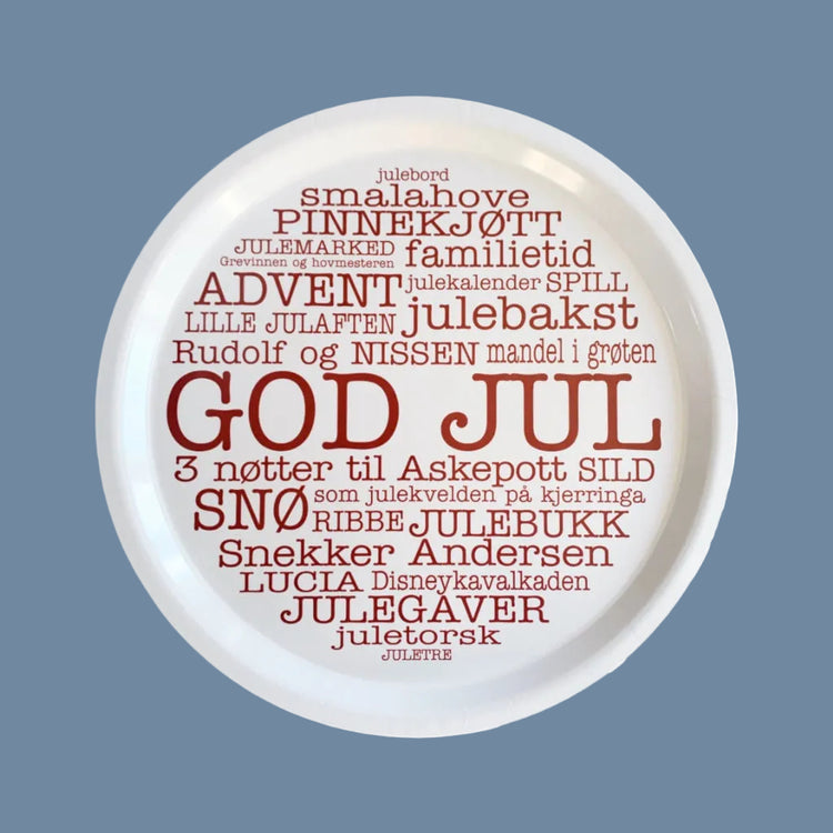 Weißes, rundes Holztablett mit roten Weihnachtswörtern auf Norwegisch