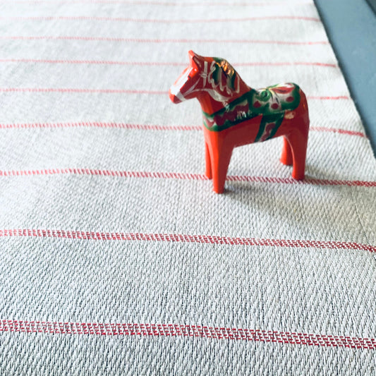 Tischläufer Högbo aus Leinen in rot auf Tisch mit Dalapferd