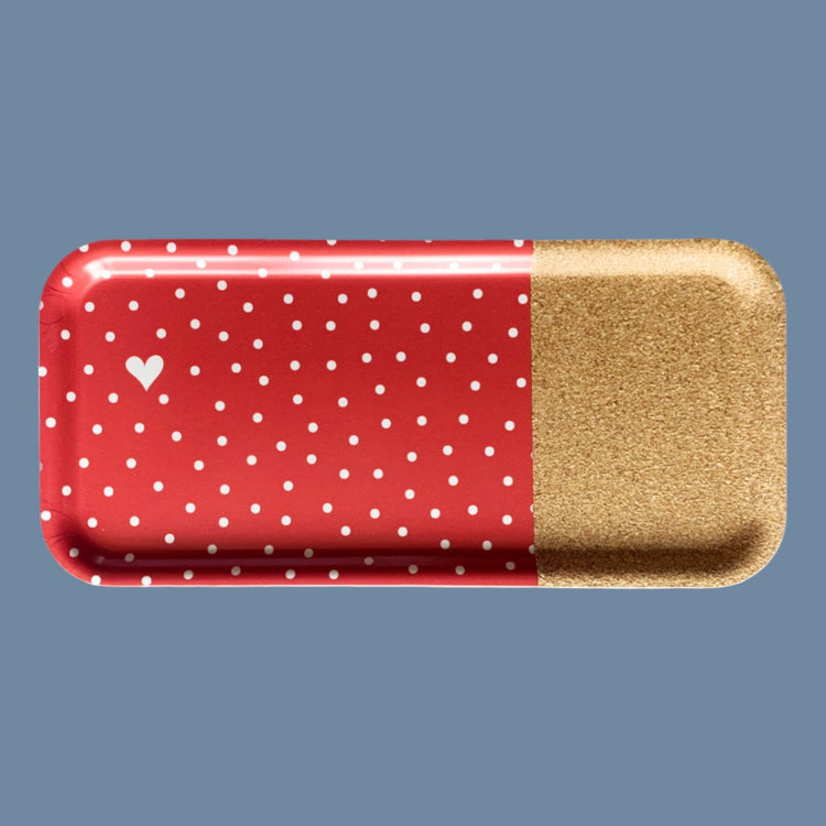 Tablett rot mit weißen Punkten und einem kleinen weißen Herz in der Mitte, ein Drittel des Tabletts hat eine Kokoberfläche