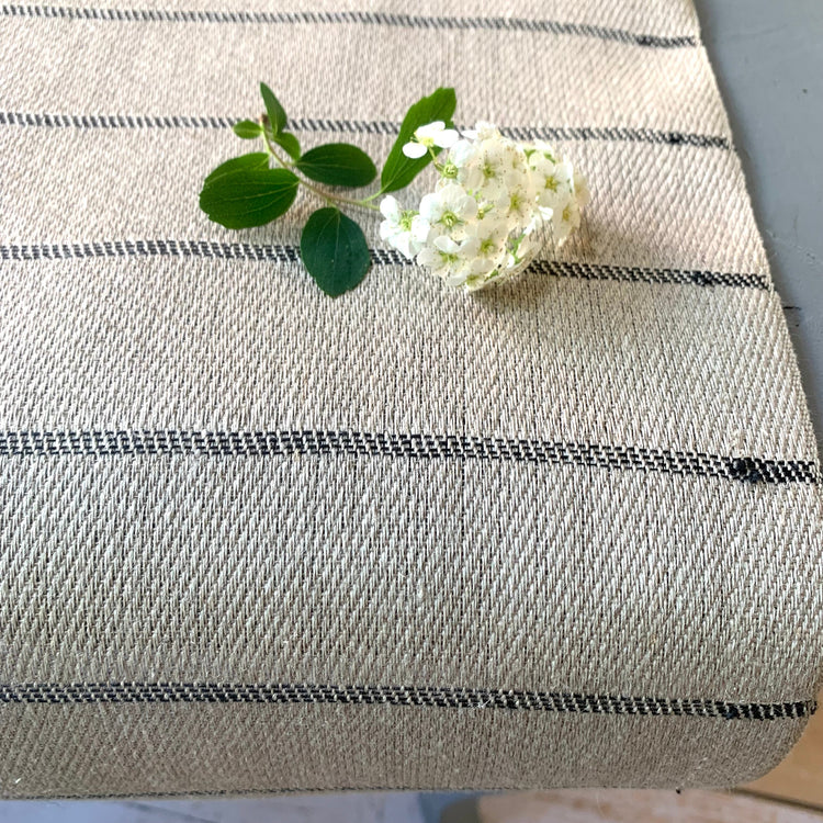 Tischläufer Högbo aus Leinen in schwarz auf Tisch mit Blüte