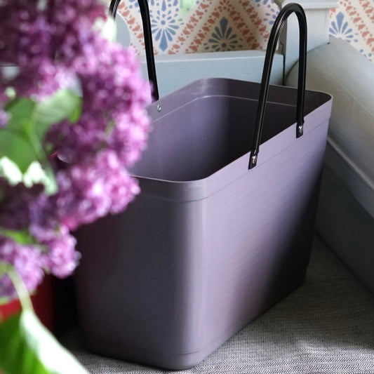 große Hinza Einkaufstasche in pflaume auf Küchensofa stehend mt Fliederstrauß im Vordergrund