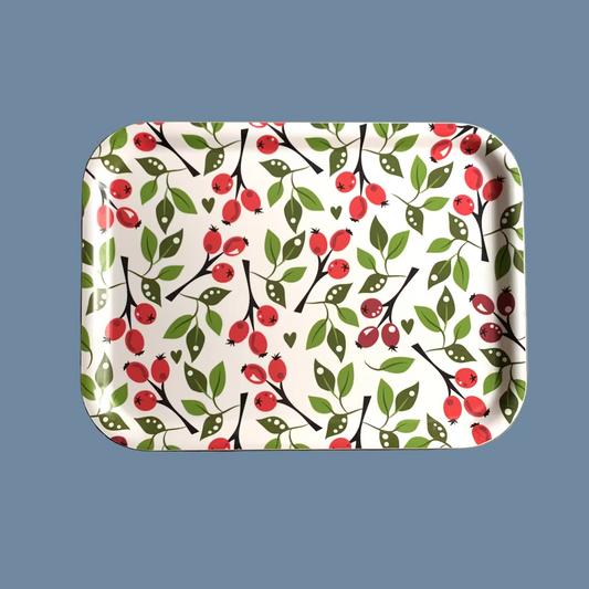 rechteckiges Holztablett mit Hagebutten vor mysblauem Hintergrund