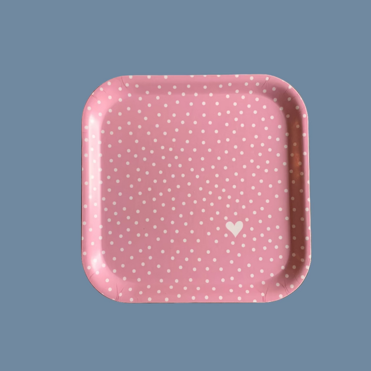 Quadratisches, rosa Holztablett mit weißen Punkten und einem weißen Herz in der rechten unteren Ecke