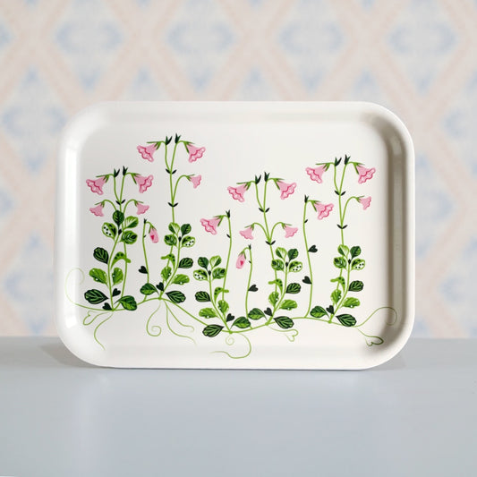 rechteckiges Holztablett mit Linneablüten und -blättern in rosa und grün auf weißem Hintergrund