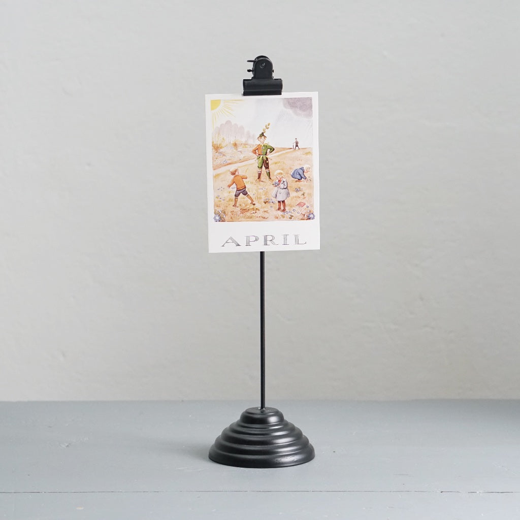 Fotohalter aus Metall in schwarz mit Postkarte mit Motiv April von Elsa Beskow