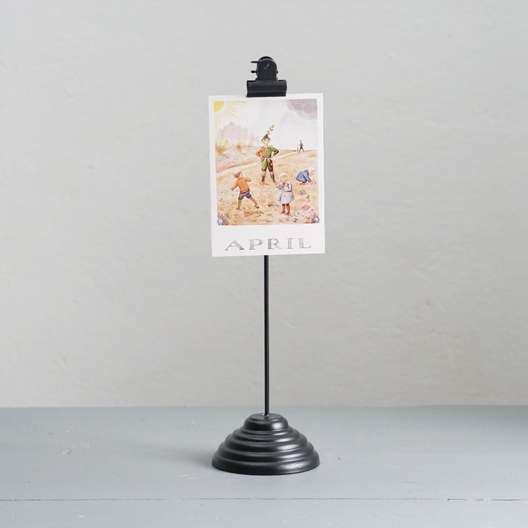 Fotohalter aus Metall in schwarz mit Postkarte mit Motiv April von Elsa Beskow