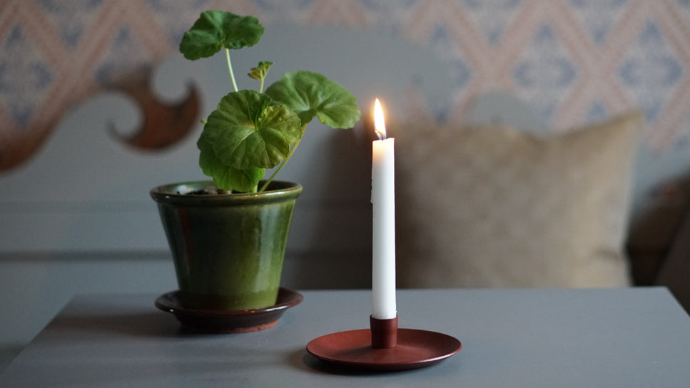 Kerzenständer Klassisk Metall rostrot mit Gränsfors Blumentopf grün vor schwedischem Küchensofa