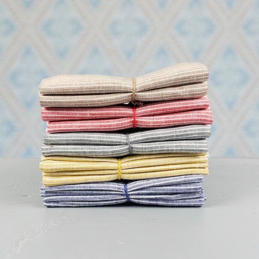 Geschirtuch Kritstreck aus Leinen verschieden Farben im Stapel vor Schwedentapete