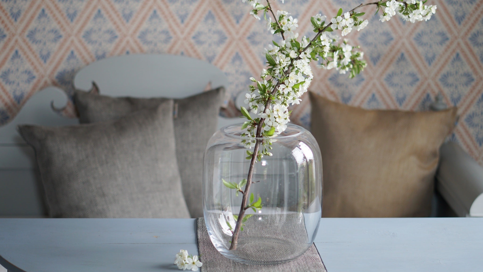 Kirschblüten Zweig in Vase vor Küchensofa