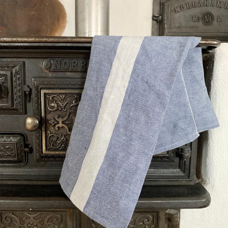 blaues Handtuch Linjal über der Reling des Küchenofens hängend