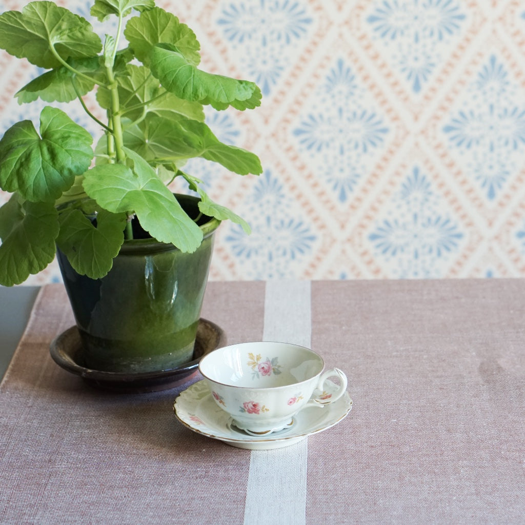 Tischläfer Linjal puderrosa auf Tisch mit kaffeetasse und Pelargonie