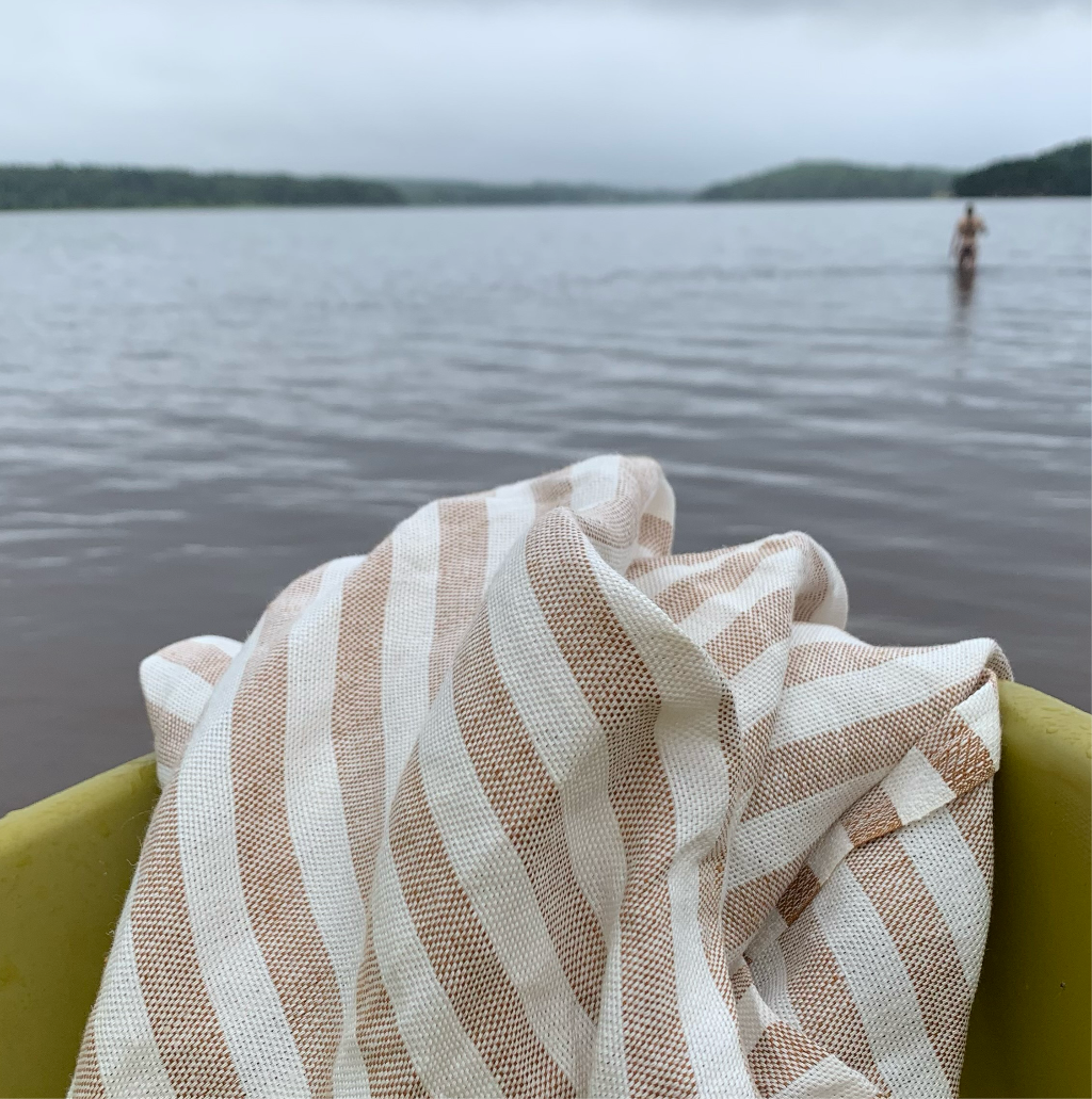 Badetuch Regnbåge aus Leinen in ziegelrot/sand auf Boot am See
