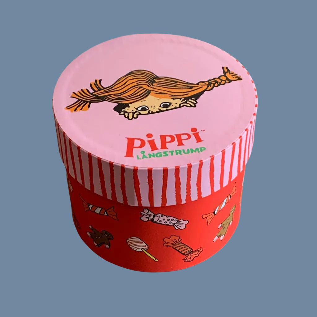 Runde Pappschachtel mit Deckel, Körper rot mit kleinen Bonbon-Illustrationen, auf dem Deckel ein Pippigesicht, so als schaute es aus dem Deckel