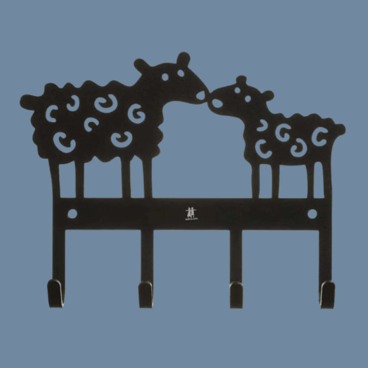 zwei ausgestanzte Schafe, die sich einander zuwenden und mit den Nasen anstipsen, Beine stehen auf einer Leiste mit vier Haken