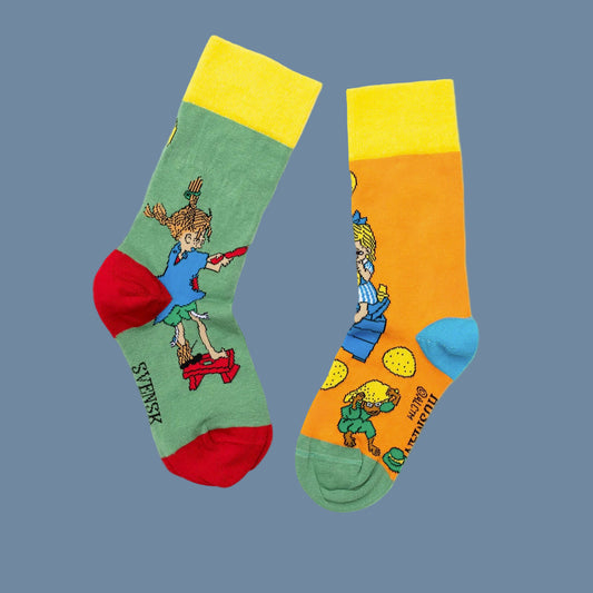 ein grüner und ein oranger Strumpf mit Pippi und Annika drauf beim Plinsenbacken