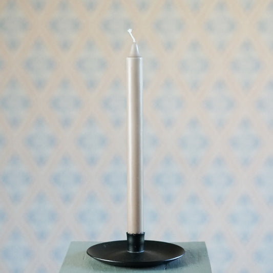 Kerze aus Stearin in dunkelbeige in schwarzem Tellerleuchter