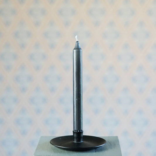 dunkegraue Kerze in schwarzem Kerzenhalter aus Metall