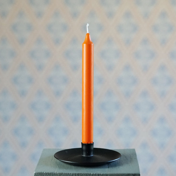 Kerze 24 cm aus Stearin in orange auf einem schwarzen Tellerleuchter
