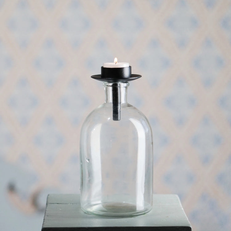 Kerzenhalter für Teelichter aus schwarzem Metall von Våges auf einer bauchigen Flasche