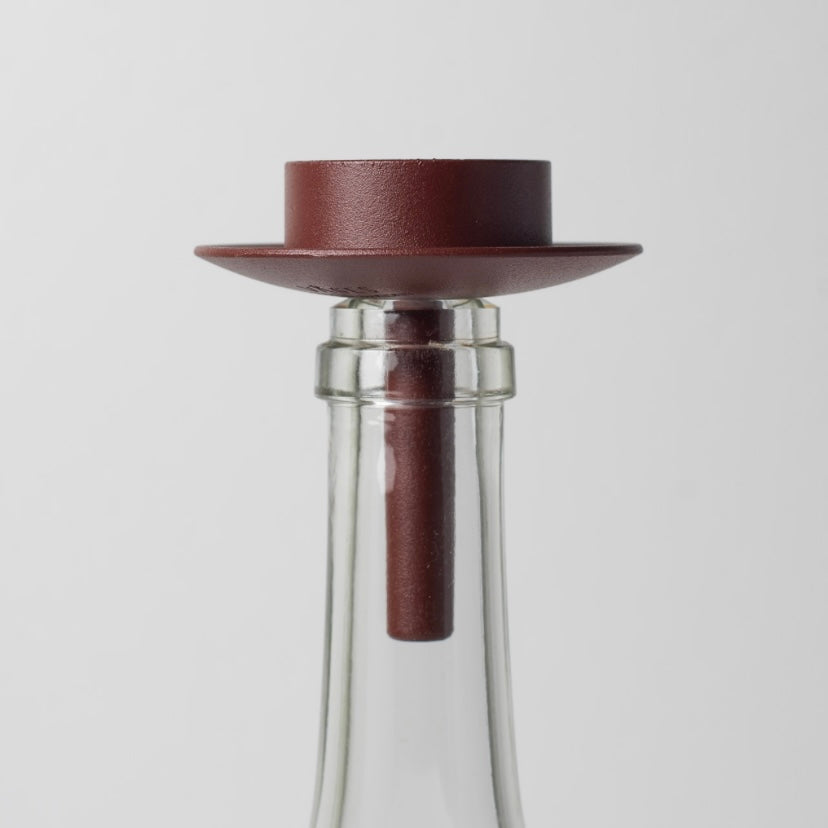 Teelichthalter aus Metall rostrot auf weißer Glasflasche