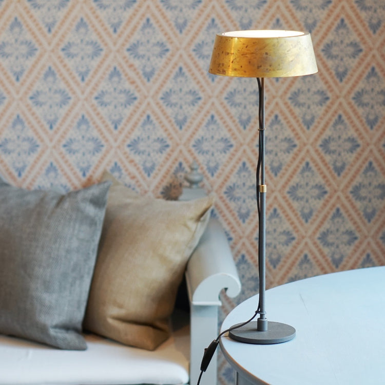 Tischlampe Karl groß auf Tisch neben Küchensofa mit zwei Leinen Kissen, im Hintergund Wand mit typisch schwedischer Tapete