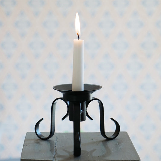 Kerzenhalter Vändbar mit brennender Tafelkerze, der Halter sitzt oberhalb der Füße