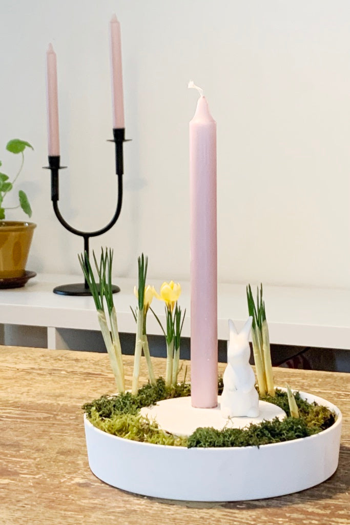 Kerzenhalter aus Keramik mit Moos und Krokussen im äußeren Ring und Kerze und Hase auf dem erhöhten Mittelteil