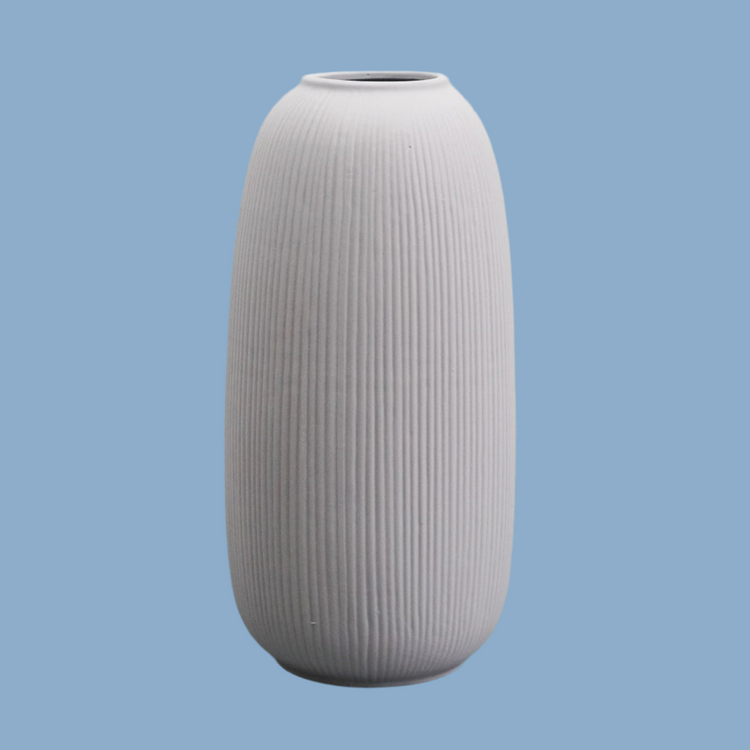 Keramikvase in länglich bauchig in grau vor blauem Hintergrund